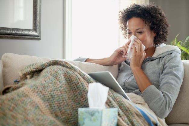 Woman at home with flu symptoms